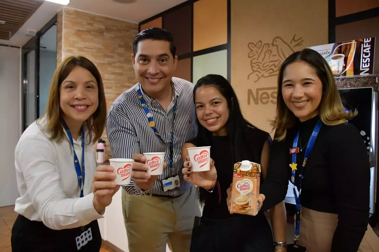 Conjunto de personas mostrando sus vasos con el logo de coffee mate