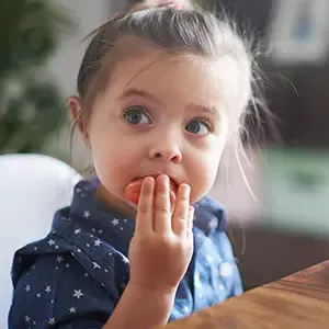 Niña comiendo tomate